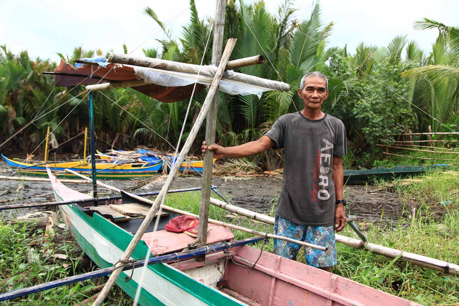 IMPACT ON FISHERFOLK. Rofino Tarzuna, a fisherman in Dingalan, Aurora poses with the boat he infrequently uses out on the sea.
Photo: Kathleen Lei Limayo 