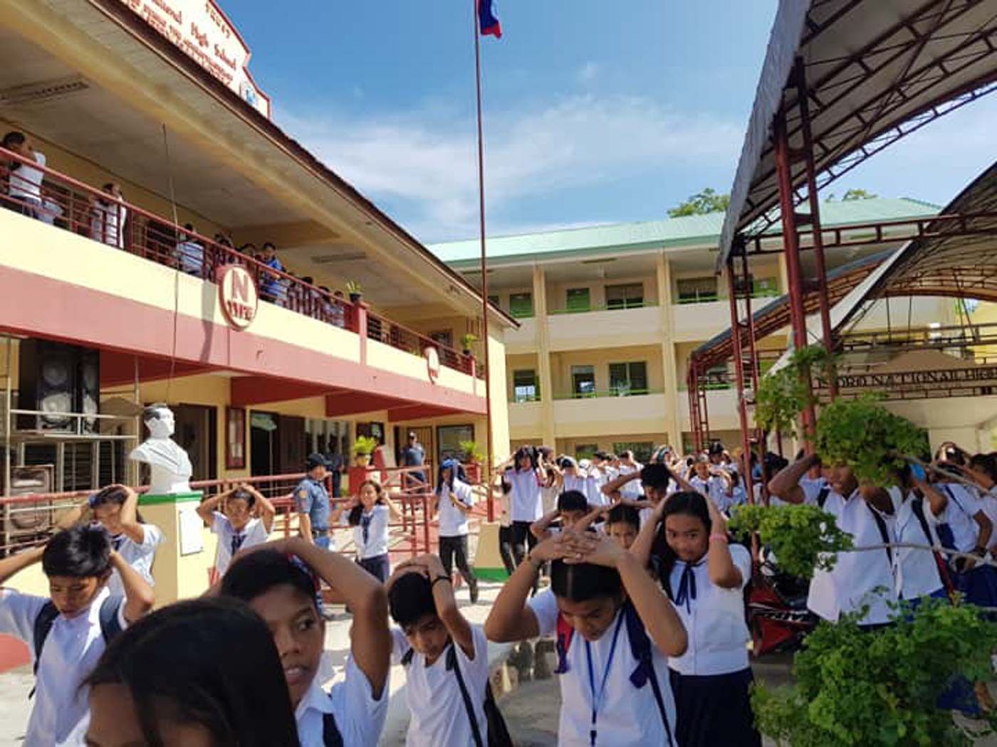 ASSIST. Students and staff of the San Isidro National High School are assisted by members of the local police. Photo from Catanauan Police Facebook page 