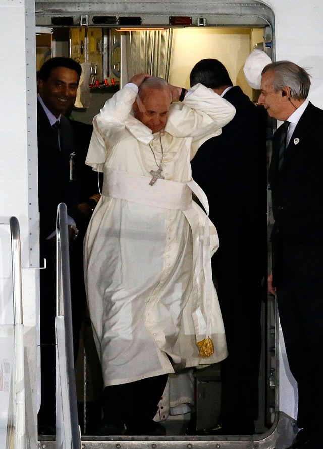 Pope Francis (L) tries to catch his skullcap on his arrival at the airport in Manila, Philippines, 15 January 2015. Dennis M. Sabangan/EPA