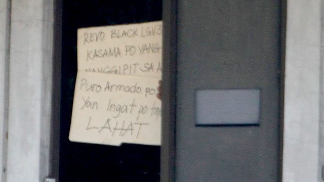 WARNING. The unidentified person warns bystanders about 'armed' personalities near the building. Photo by Mark Saludes/Rappler   