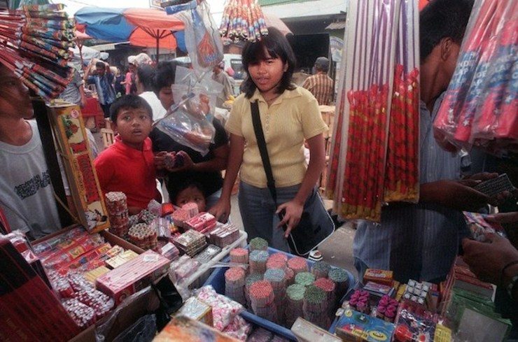 Para penonton memilih berbagai macam kembang api yang dijual secara ilegal di kawasan preman Tanah Abang, Jakarta.  Pihak berwenang telah melarang penjualan petasan karena risiko pembakaran yang serius, namun beberapa toko masih menjualnya.  Foto oleh Dimas/AFP