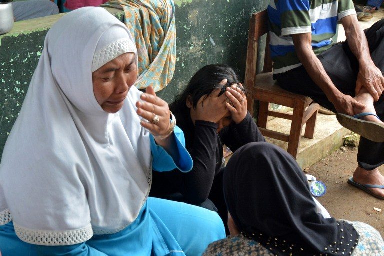 SURVIVOR.  Foto yang diambil pada 13 Desember 2014 di desa Jemblung di Banjarnegara, Jawa Tengah ini menunjukkan penduduk desa menangisi orang-orang yang mereka cintai saat operasi penyelamatan berlanjut di daerah tersebut setelah tanah longsor pada 12 Desember.  Foto oleh AFP 