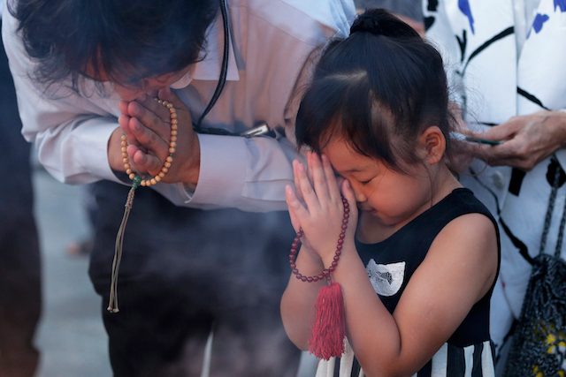 Seorang gadis cilik ikut berdoa bersama orang tuanya untuk korban jatuhnya bom atom di Hiroshima, Jepang