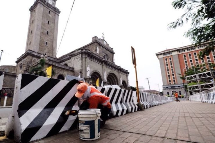 Seorang pekerja mengecat barikade yang didirikan di sekitar Katedral Manila untuk kunjungan kepausan.  Foto oleh Pat Nabong