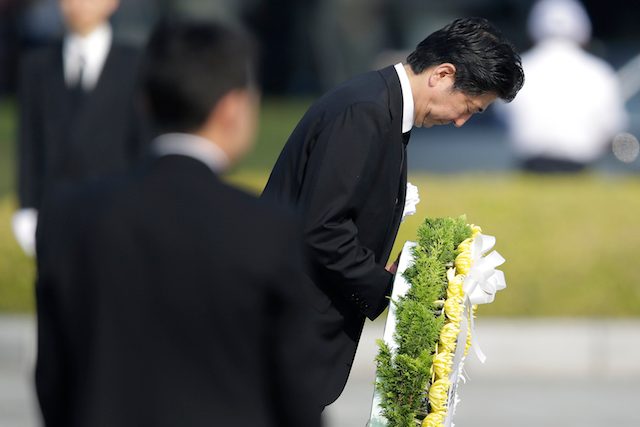 Perdana Menteri Jepang Shinzo Abe saat memberi hormat dan menaruh karang bunga di monumen peringatan jatuhnya bom atom di Hiroshima