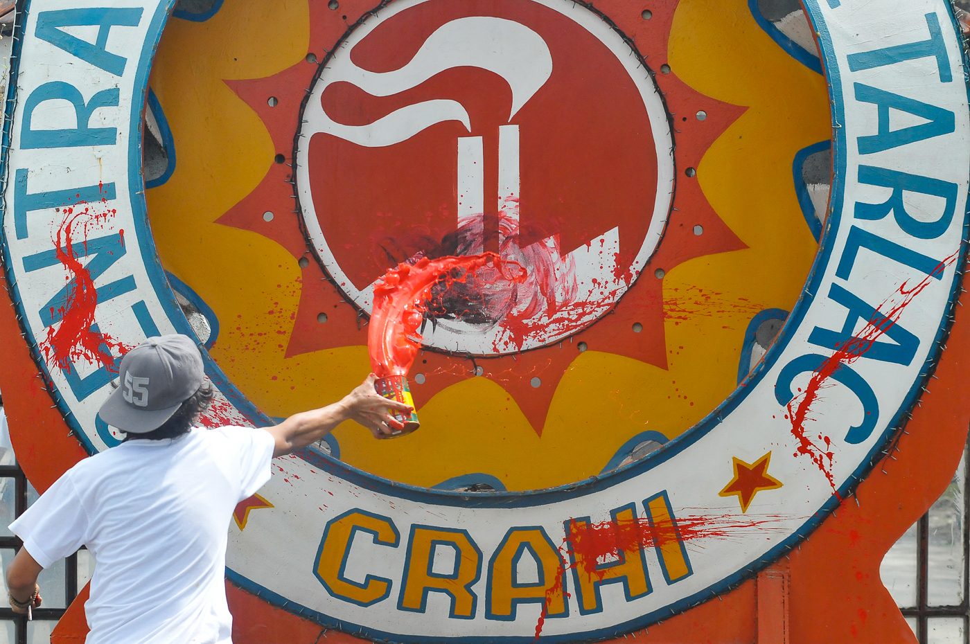 PROTEST. Activists throw red paint against the logo of the Central Azucarera de Tarlac during the 12th anniversary of the Hacienda Luisita massacre. 