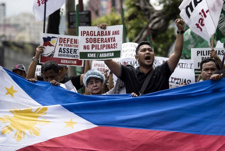 ASSERTING THE RULING. Activists participate in a protest in front of the Chinese embassy in Makati on July 12, 2018, to mark the second anniversary of the Hague ruling saying there was no basis for China's claims to most of the South China Sea. Photo by Noel Celis/AFP   