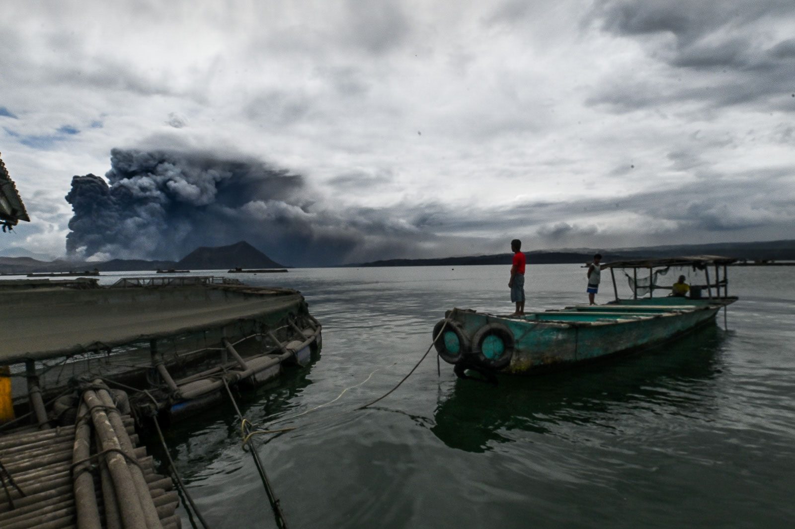 AWAKE. Fisherman Rolando Leanos watches from his boat in Laurel, Batangas, on January 13, 2020, as Taal Volcano spews ash. File photo by Alecs Ongcal/Rappler 